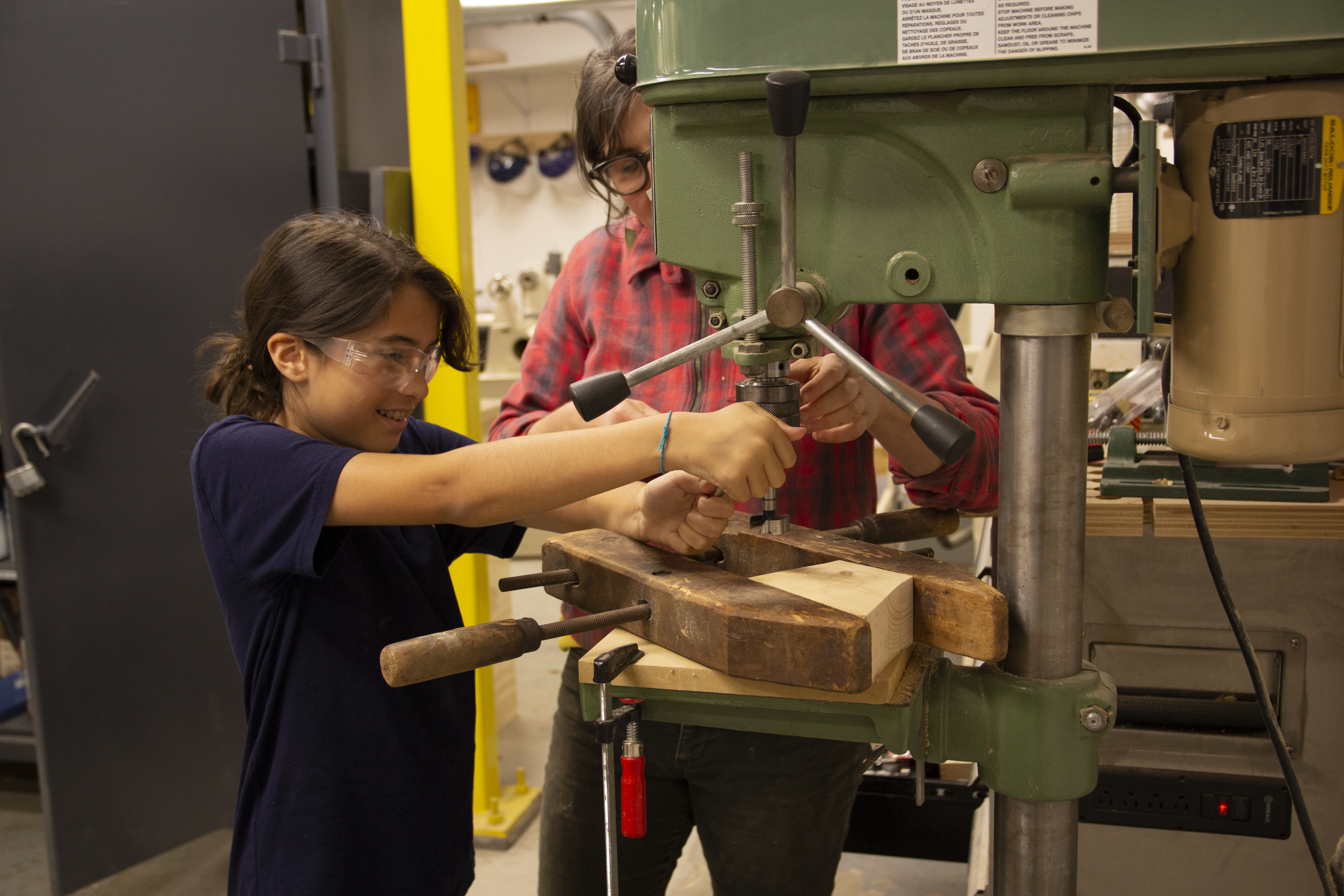 SkillSet Woodshop Instructor teaches student how to use the drillpress